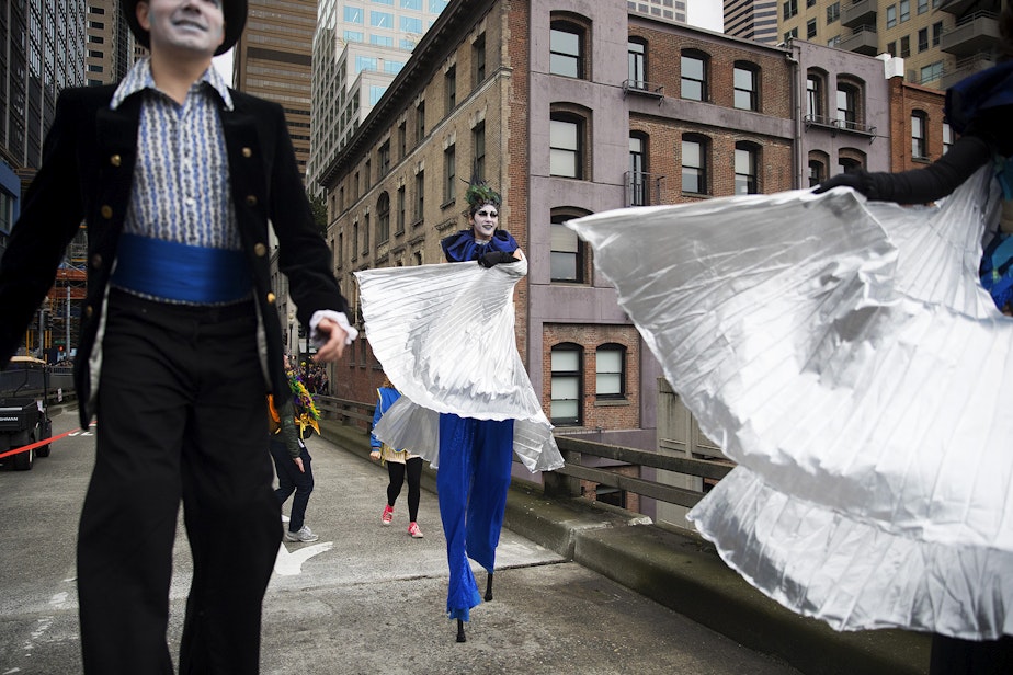 caption: April McMorris, center, walks with other members of The Cabiri, during the Hello Goodbye music and performance procession on Saturday, February 2, 2019, at the Viaduct Arts Festival in Seattle. 
