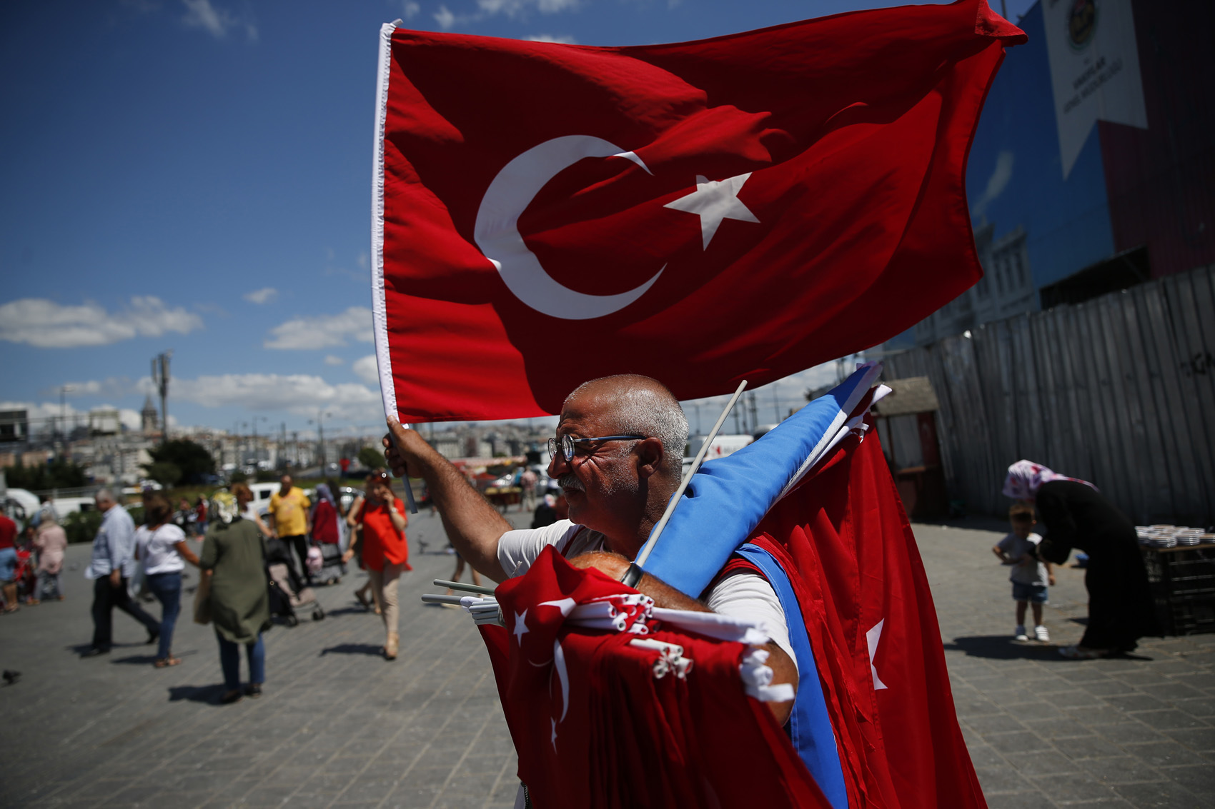 caption: A vendor offers Turkish flags for sale at a market in Istanbul, Monday, Aug. 13, 2018. Turkey's central bank announced a series of measures on Monday to free up cash for banks as the country grapples with a currency crisis sparked by concerns over President Recep Tayyip Erdogan's economic policies and a trade and diplomatic dispute with the United States. (Lefteris Pitarakis/AP)