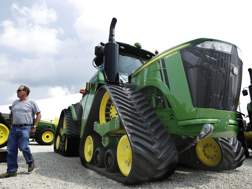 caption: John Deere is known for its signature green and yellow farm equipment, like this equipment on display in 2015 at the Farm Progress Show in Decatur, Ill.