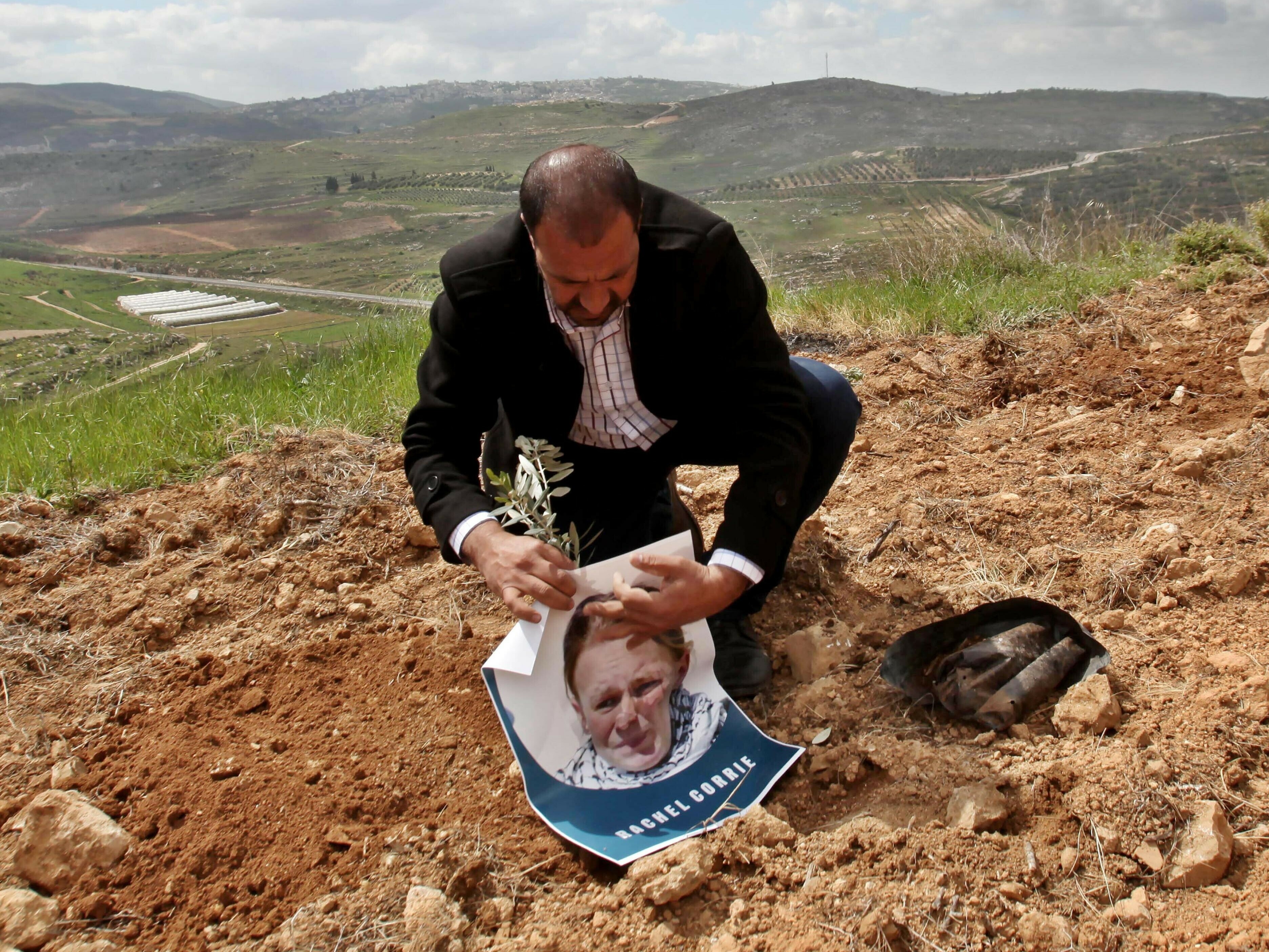 caption: A group gathering in Qaryut village southeast of Nablus, West Bank, on March 15, 2015, plant an olive tree as they mark the 12th anniversary of the death of U.S. activist Rachel Corrie, who died when she was crushed by an Israeli bulldozer in the Gaza Strip on March 16, 2003.