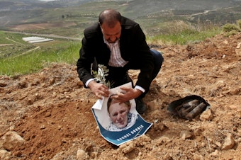 caption: A group gathering in Qaryut village southeast of Nablus, West Bank, on March 15, 2015, plant an olive tree as they mark the 12th anniversary of the death of U.S. activist Rachel Corrie, who died when she was crushed by an Israeli bulldozer in the Gaza Strip on March 16, 2003.