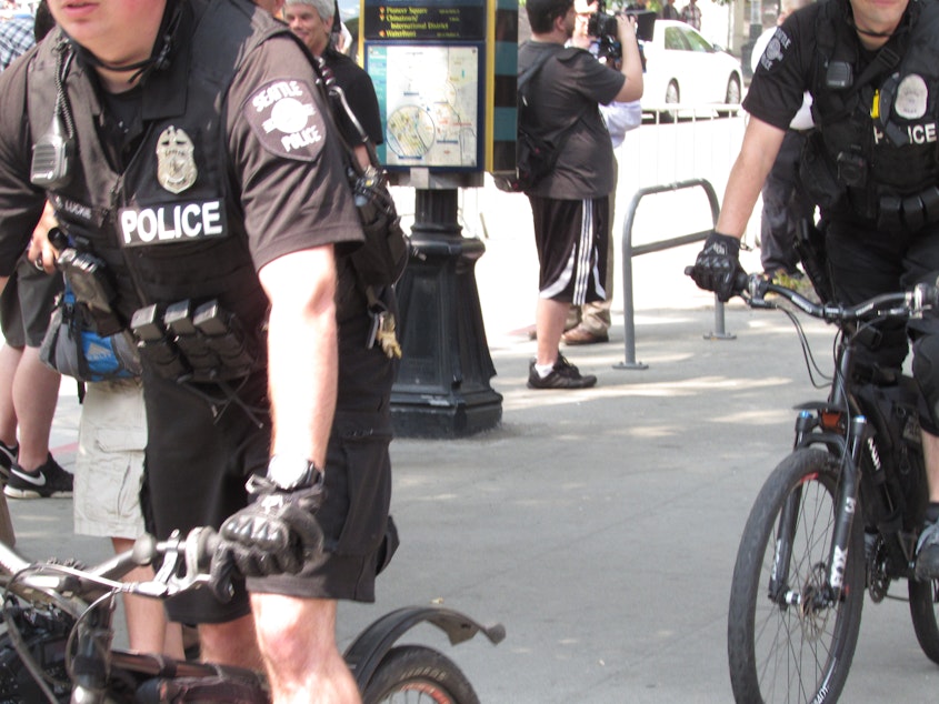 caption: SPD officers separated opposing protest groups in August 2018. The department lost more officers than it gained that year.
