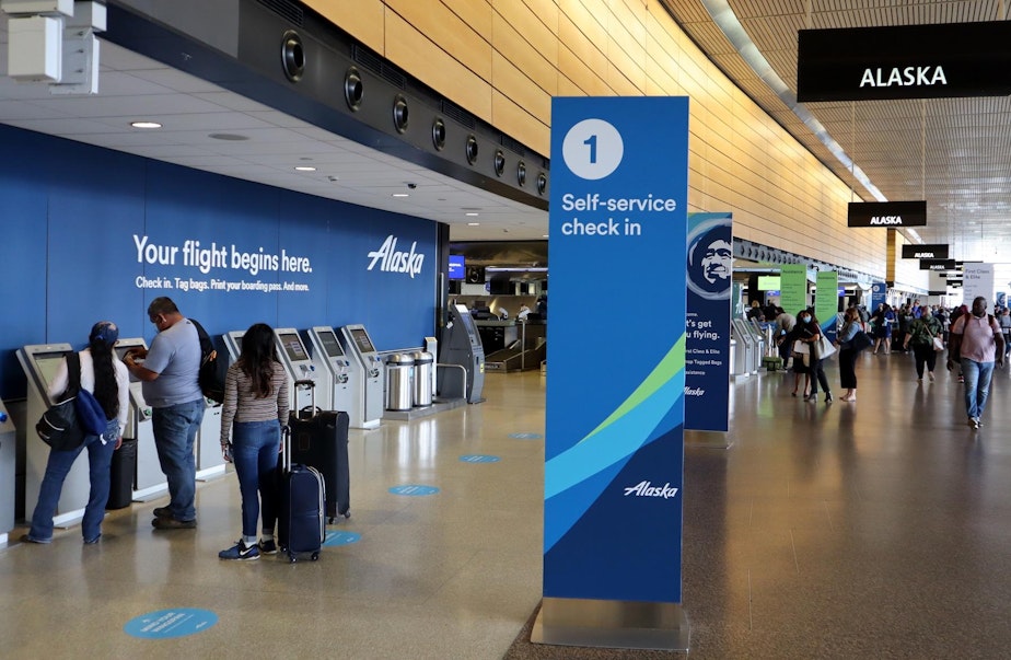 caption: Departing passengers at Sea-Tac International Airport have lots of check-in kiosks to choose from with air traffic still way down from last year.
