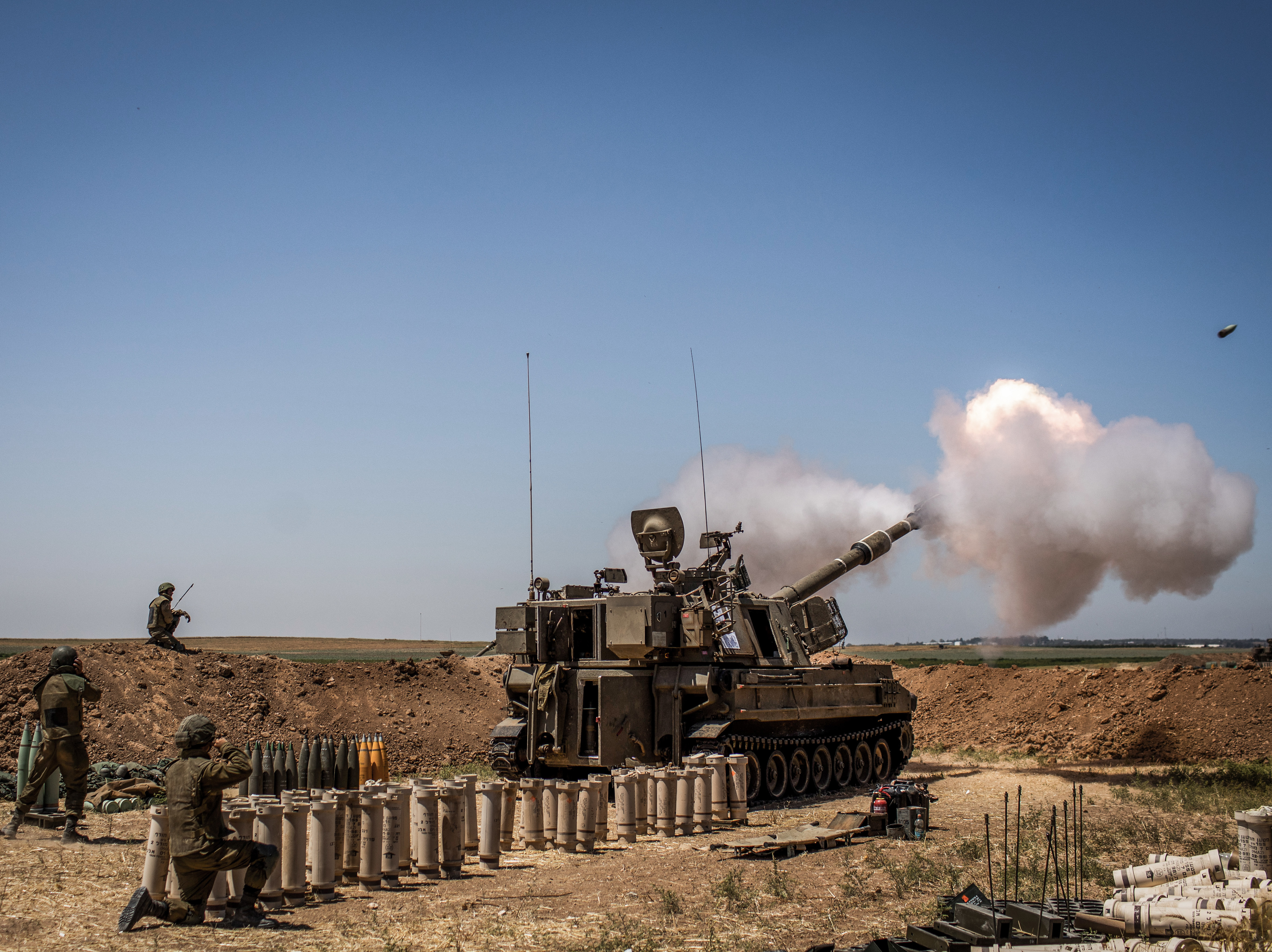caption: Israeli artillery fires toward the Gaza Strip from a position at the Israeli-Gaza border near Sderot on Wednesday.
