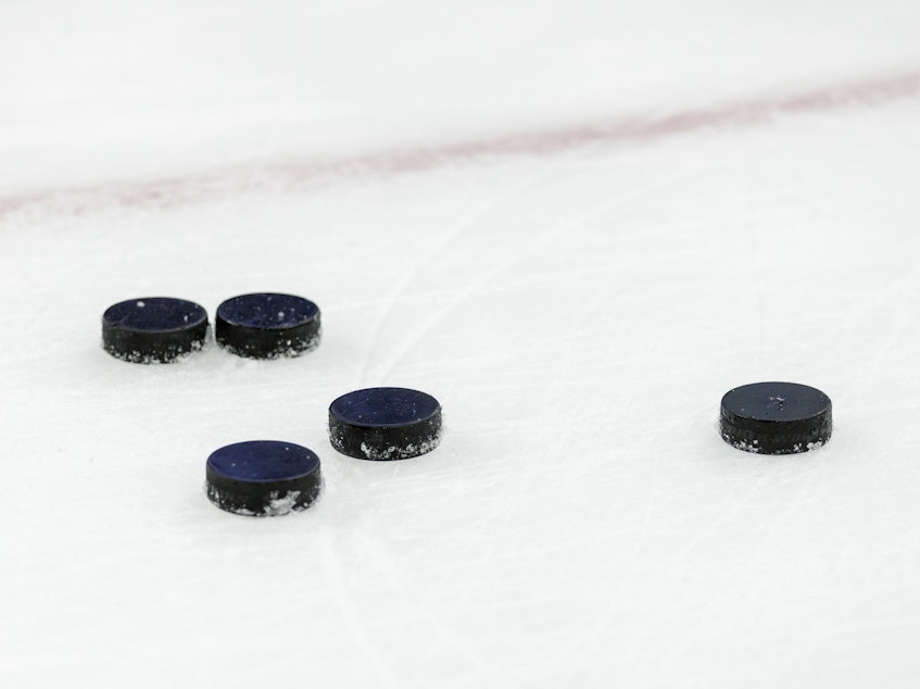 caption: Hockey pucks on ice at Nationwide Arena in Columbus, Ohio.