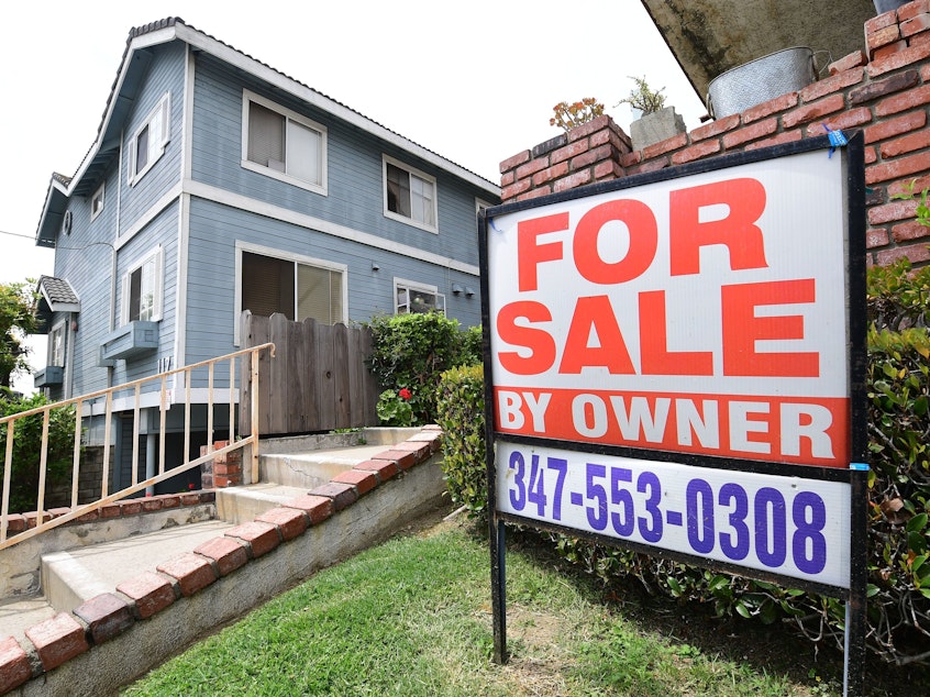 caption: A "For Sale by Owner" sign is posted in front of property in Monterey Park, Calif., in April 2020.