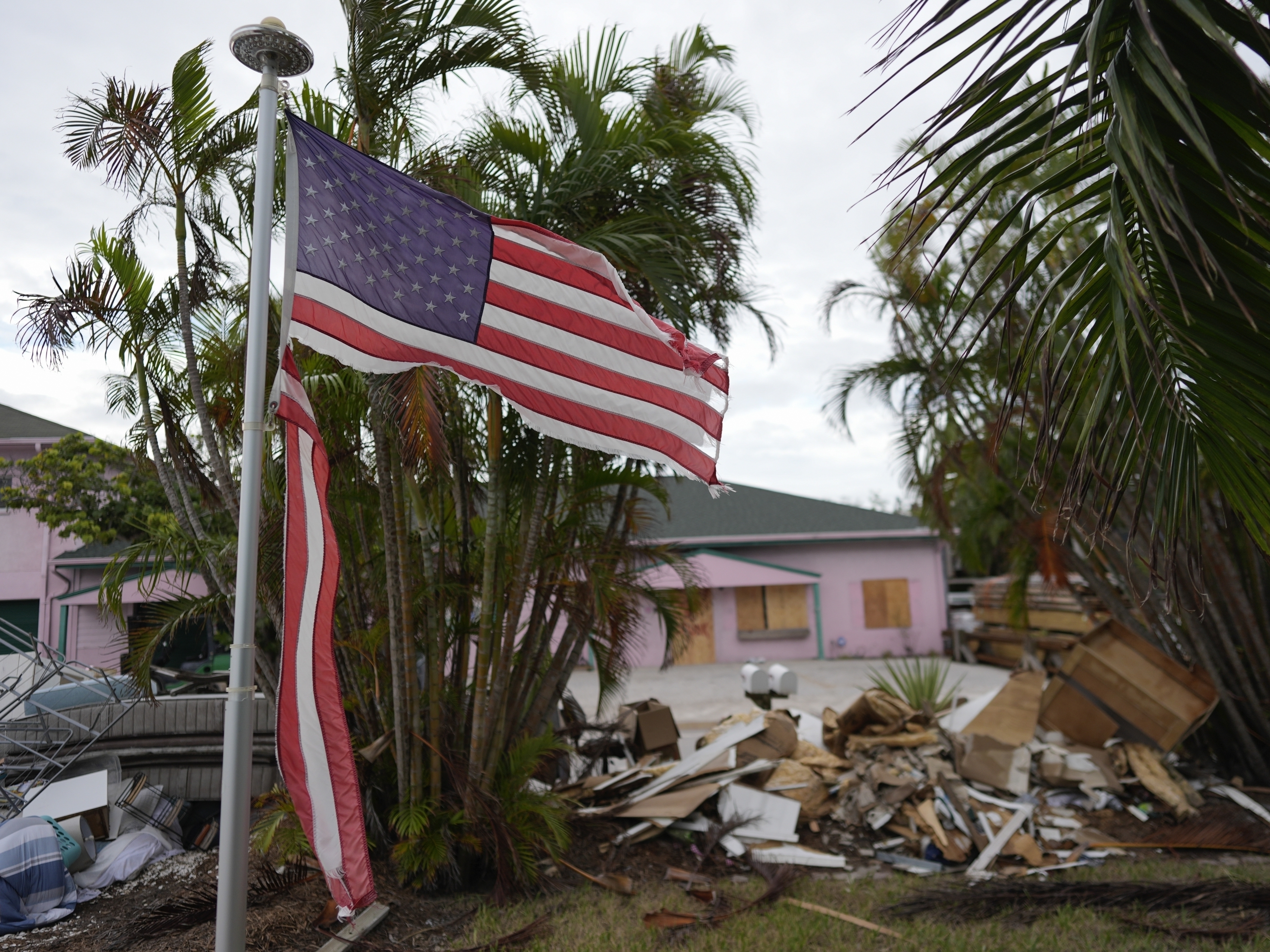 caption: A tattered American flag flaps outside a home after Hurricane Helene and before the arrival of Hurricane Milton, on Anna Maria Island, Fla., last month.