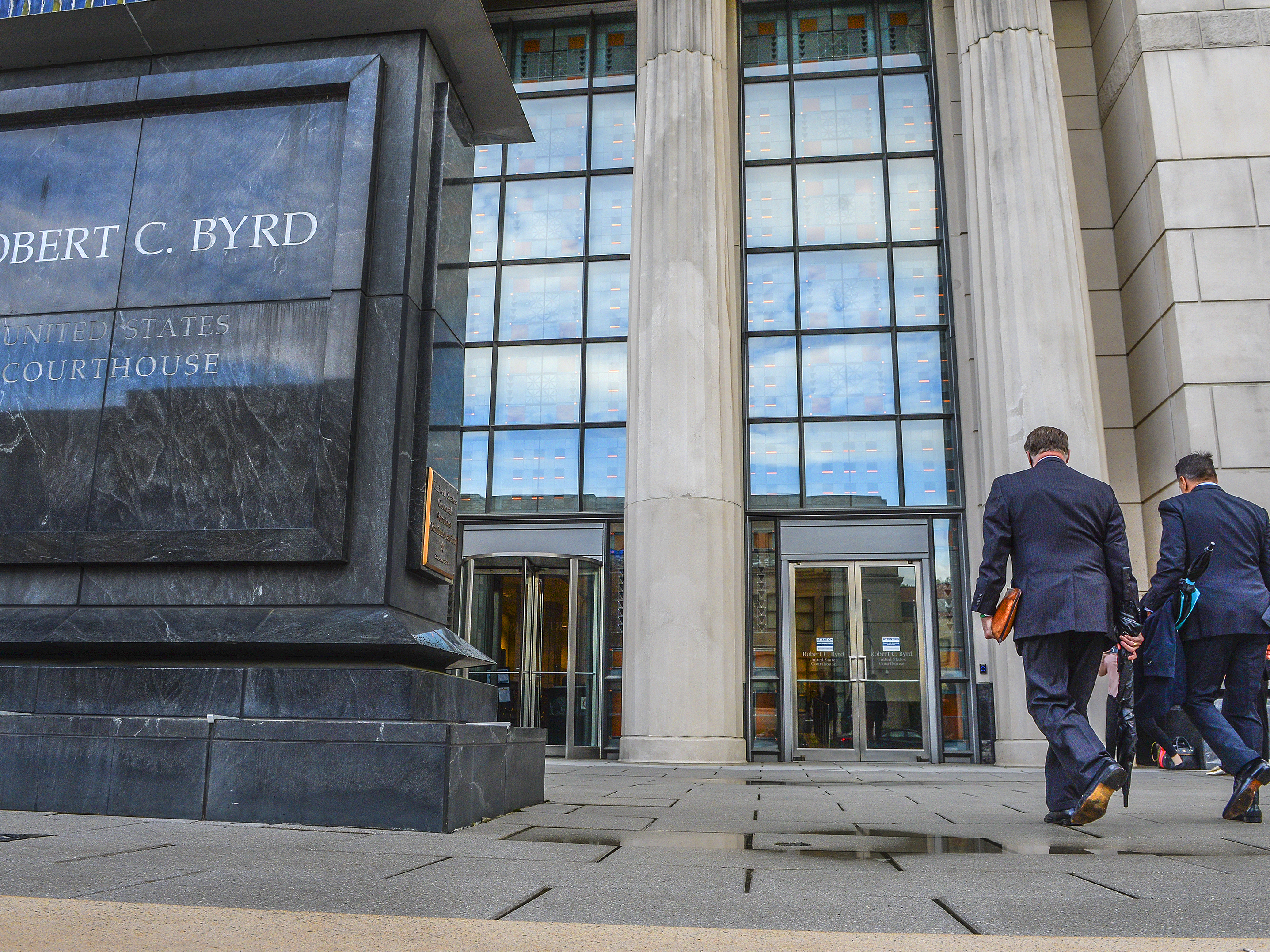caption: Huntington, W.Va., Mayor Steve Williams, left, and lawyer Rusty Webb enter the Robert C. Byrd United States Courthouse in Charleston, W.Va., in May. A federal judge on Monday ruled in favor of three major U.S. drug distributors in a landmark lawsuit that accused them of causing a health crisis in a West Virginia county ravaged by opioid addiction.