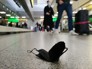 caption: A discarded mask is seen on the floor inside New York's John F. Kennedy Airport on Tuesday, a day after a federal judge in Florida struck down the CDC's mask mandate for public transportation.