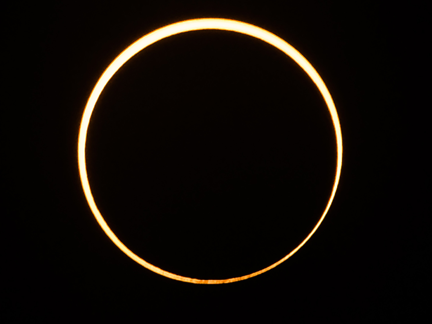 caption: The moon moves in front of the sun in a rare "ring of fire" annular solar eclipse, as seen in the sky over Singapore on Thursday.