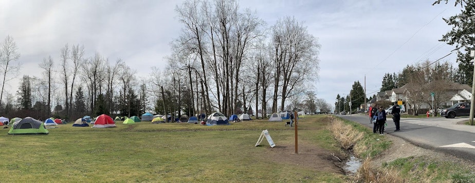 caption: Binational couples set up tents in Peace Arch State Park to give their daytime reunions a little more privacy. The U.S.-Canada border runs along the ditch at right.