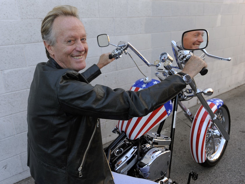 caption: Peter Fonda poses in 2009 atop a Harley-Davidson motorcycle based on the one he rode in the 1969 film <em>Easy Rider</em>.