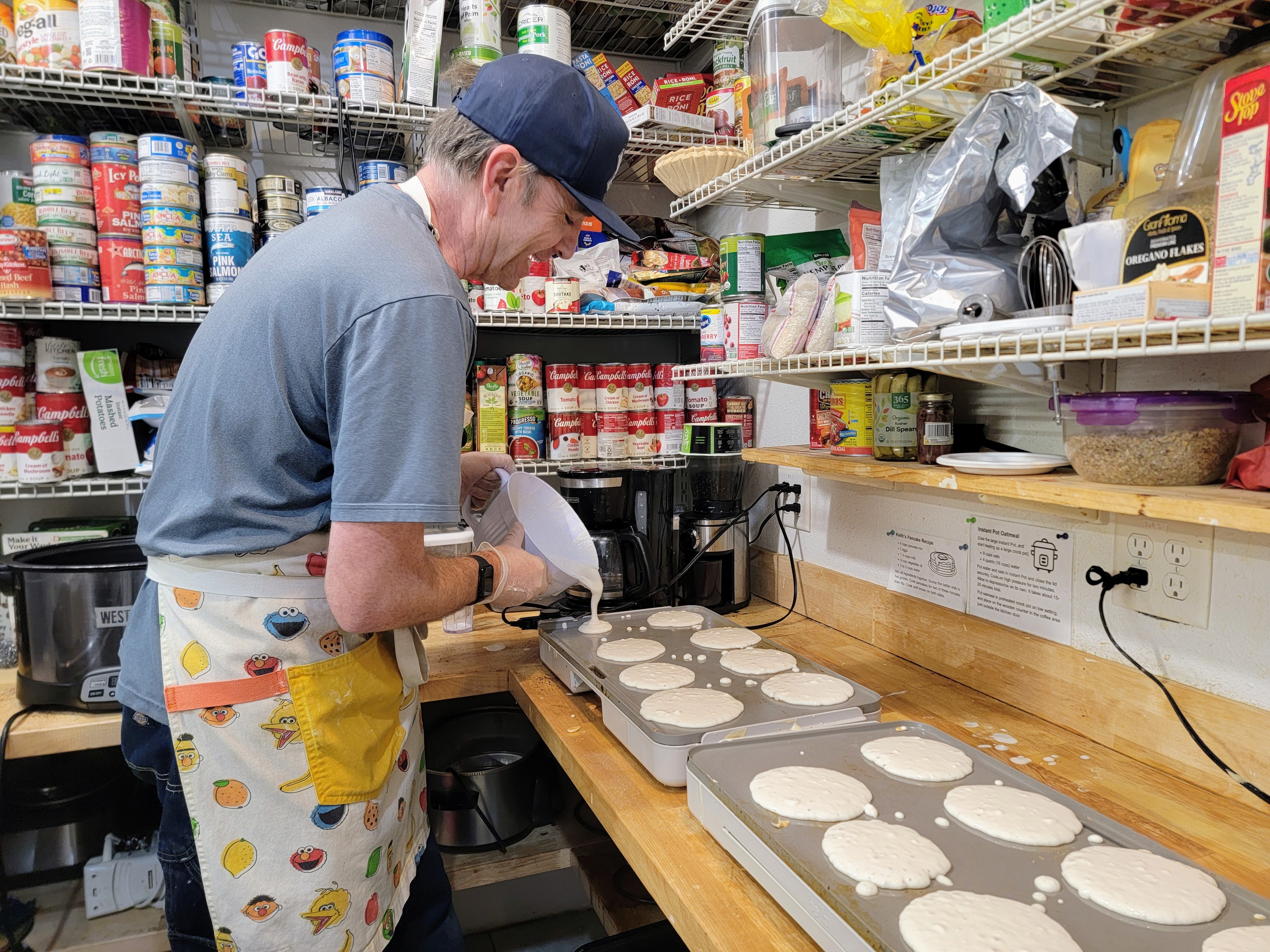 caption: Volunteer Ryan DeLuccio says his method to making hundreds of pancakes at the shelter is "as fast as I possibly can."