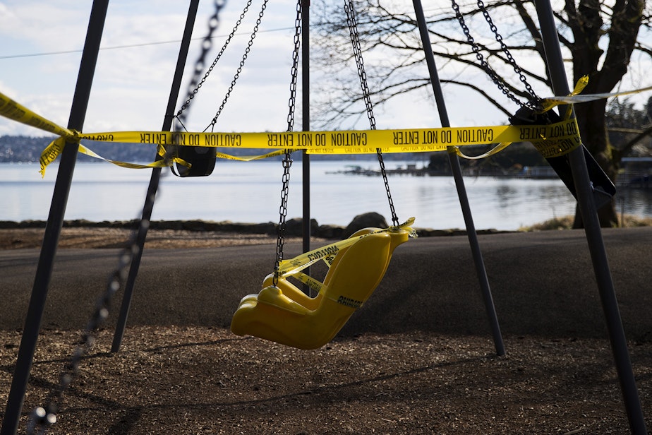 caption: A swing set is surrounded by caution tape at a closed play area as a result of the coronavirus outbreak two days after Gov. Jay Inslee announced the Stay Home, Stay Healthy order, on Wednesday, March 25, 2020, at Seward Park in Seattle.  