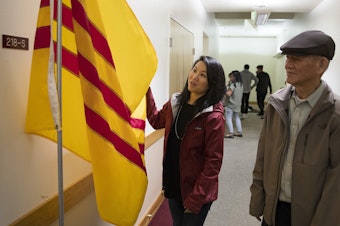 caption: Thanh Tan stands with her father, Duc Tan, as they look at the South Vietnamese flag, at Hung Vuong Vietnamese Language School inside the Lutheran Church of the Good Shepherd on Friday, September 29, 2017, in Olympia. 