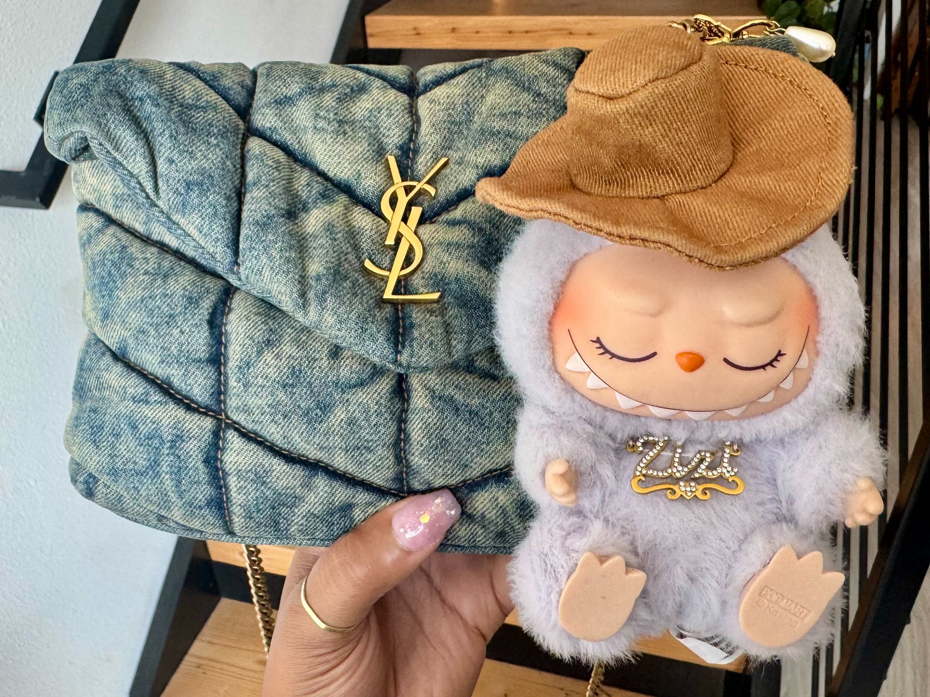 caption: Young adults have turned Lafufus into fashion items. Fans buy outfits and trinkets to customize the dolls and show them off with high-end bags. 
