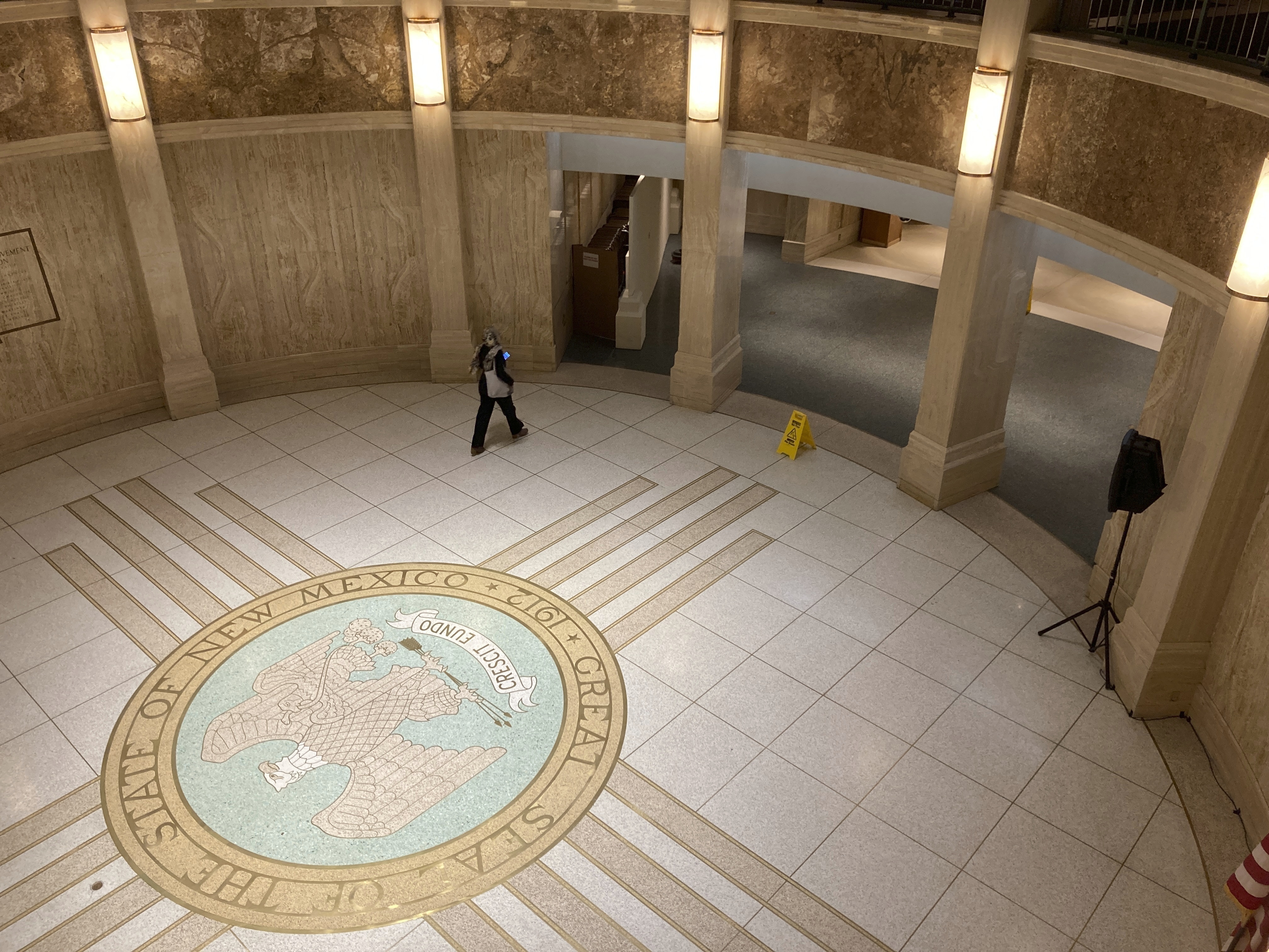 caption: A pedestrian traverses the rotunda in the New Mexico state Capitol building in Santa Fe, N.M.