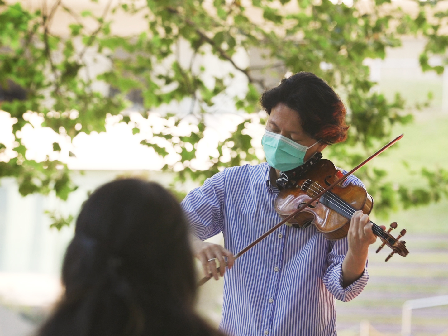 caption: New York Philharmonic first violinist Kuan Cheng Lu, playing for a socially distanced audience of two at Lincoln Center on July 31.