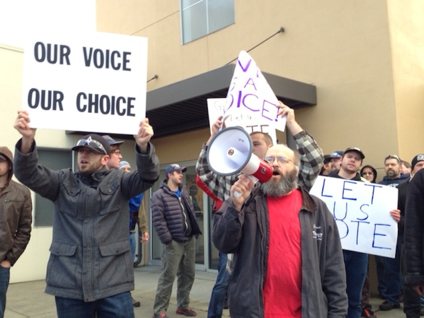 caption: Machinists marched in December to show they wanted a second vote on Boeing's 777X contract offer. The vote happened but the NLRB has judged it irrelevant.
