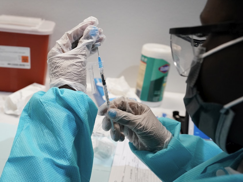 caption: A health care worker fills a syringe with the Pfizer COVID-19 vaccine at the American Museum of Natural History in New York earlier this year.