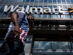 caption: A man walks past a Walmart store in Washington, D.C. on July 15. Walmart said it was "confident" that its joint deal with Microsoft would satisfy both TikTok users and U.S. government regulators.