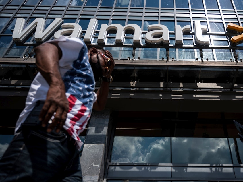 caption: A man walks past a Walmart store in Washington, D.C. on July 15. Walmart said it was "confident" that its joint deal with Microsoft would satisfy both TikTok users and U.S. government regulators.