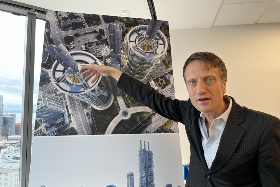 caption: Matthias Olt points at a rendering of the UN-tower produced at his previous firm, B+H Advance Strategy. 