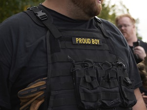 caption: A man wears a protective vest with the word Proud Boy at a Portland, Ore., rally in September. Voters in multiple states received threatening emails purportedly sent by the group, but the origin of the emails remains unknown. The group has denied responsibility.