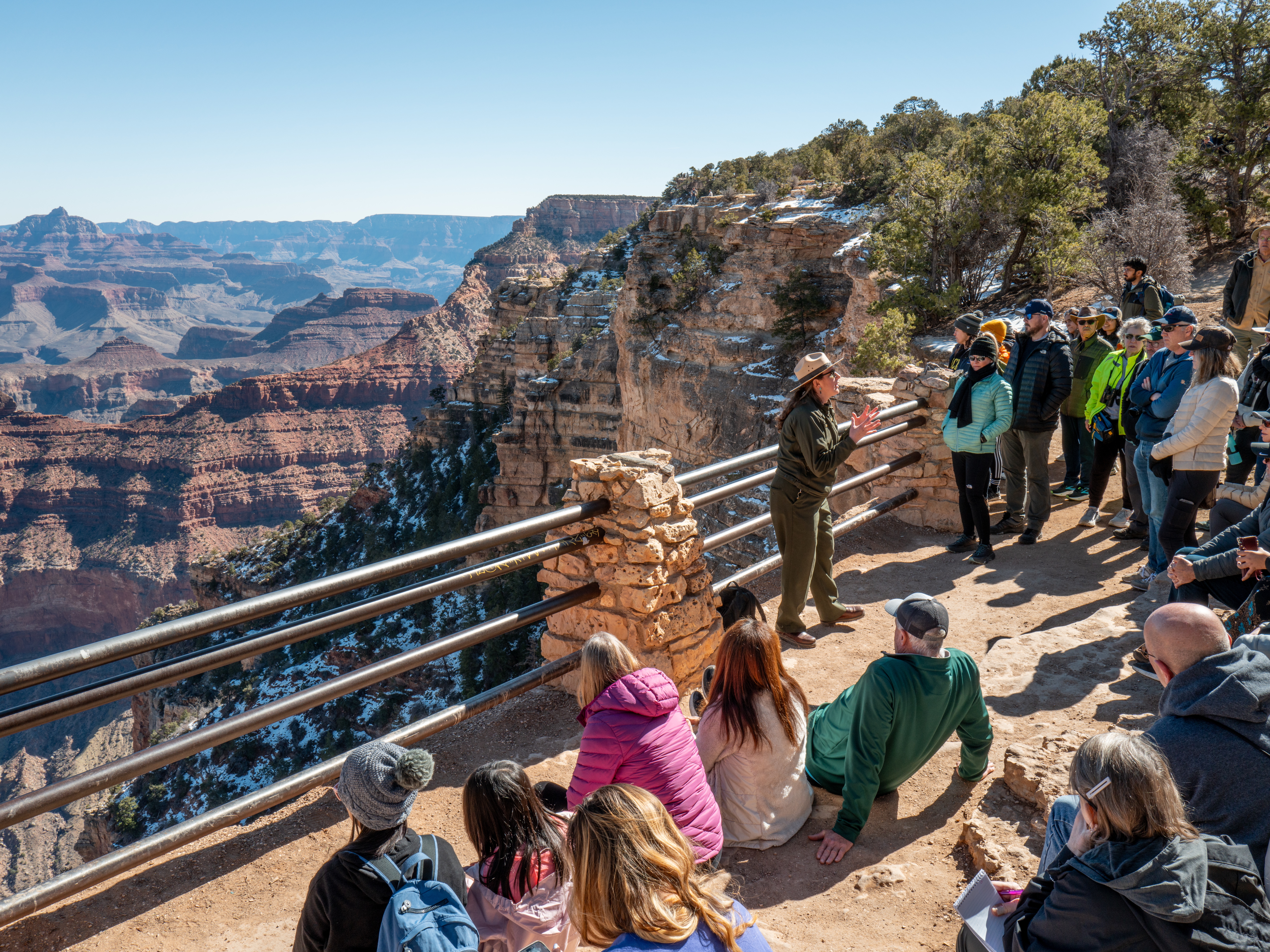 caption: A ranger gives a tour to visitors at Grand Canyon National Park on Saturday. The National Park Service is dealing with the effects of layoffs and the federal hiring freeze.