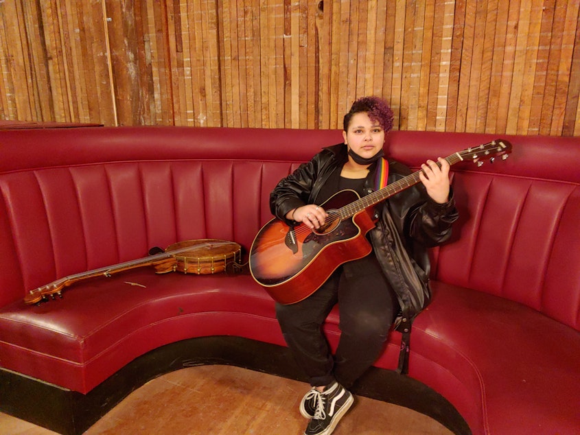 caption: Ari Whidbey messing around on their guitar before a The Rhapsody Project event at the Black and Tan Hall in Seattle, Washington on March 5, 2023. 