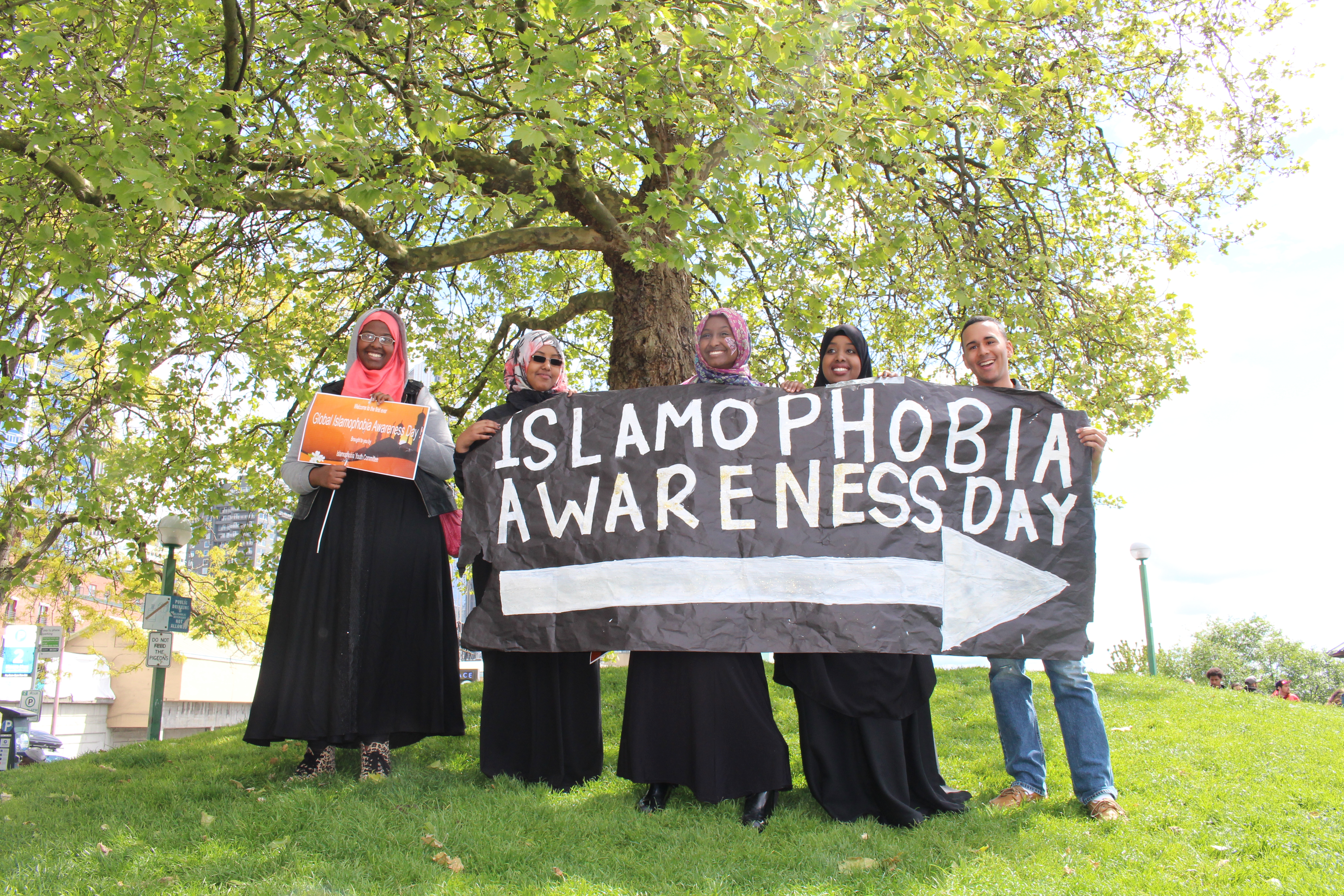caption: Youth point the way to Islamophobia Awareness Day at Victor Steinbreuck Park in downtown Seattle