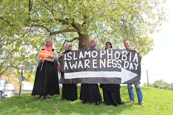 caption: Youth point the way to Islamophobia Awareness Day at Victor Steinbreuck Park in downtown Seattle