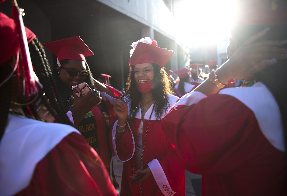 caption: Cleveland Stem High School senior Parris Sanjose laughs with classmates before the in-person commencement ceremony on Tuesday, June 15, 2021, at Memorial Stadium in Seattle. 