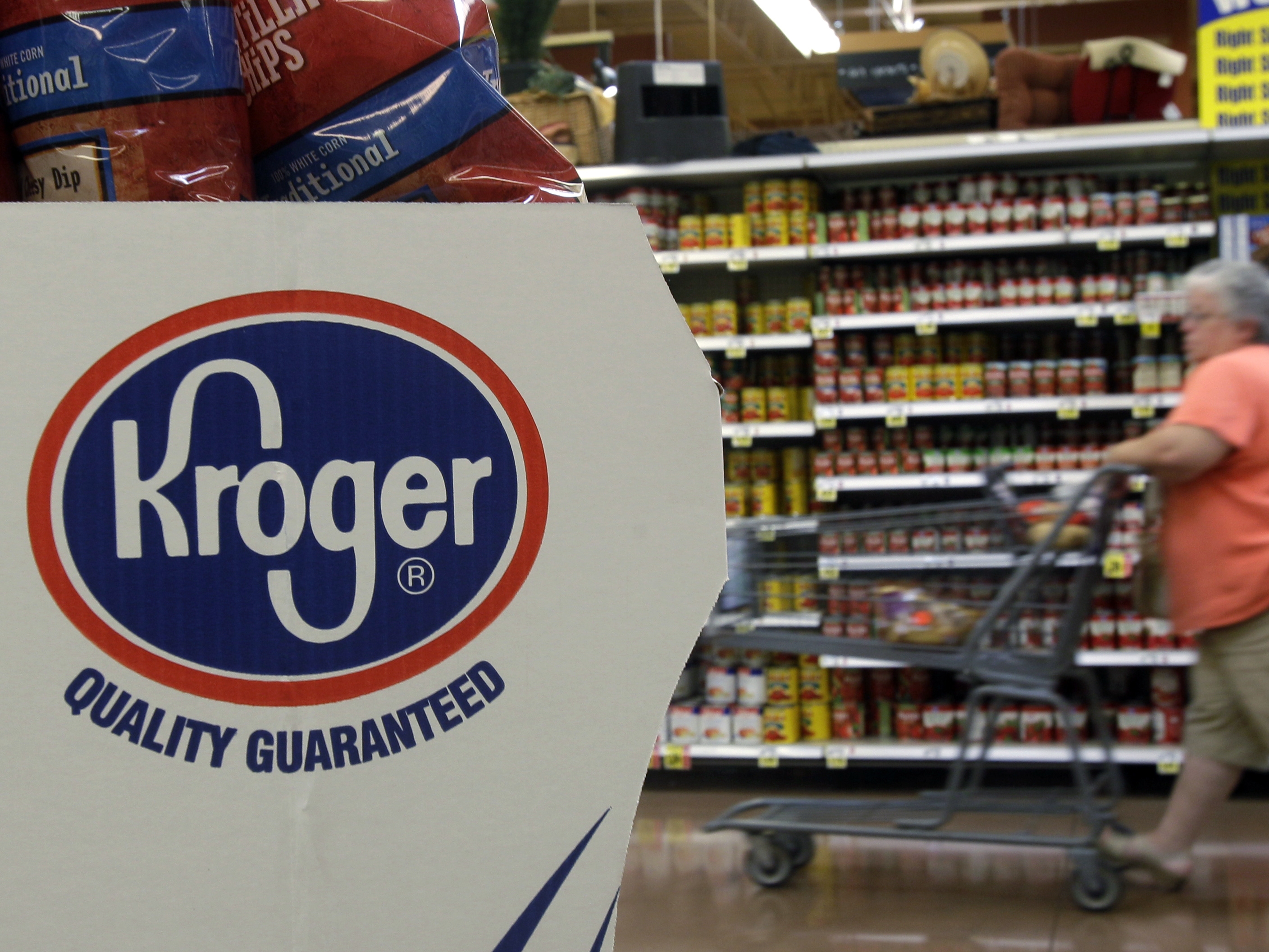 caption: A shopper pushes a cart through a Kroger supermarket in Newport, Ky.