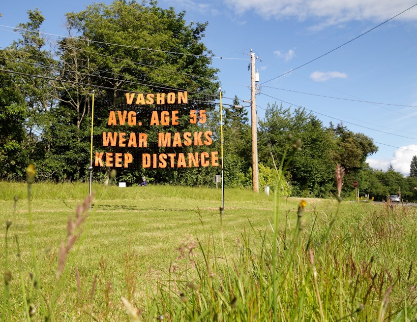 caption: A sign placed near the ferry terminal at the north end of Vashon Island reminds arrivals of their role in protecting the health of island residents.