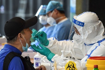 caption: A man who visited Beijing recently is tested for the coronavirus in Nanjing in China's eastern Jiangsu province on Monday.