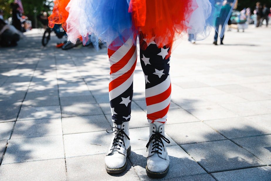 caption: Cathy Rundell wears a red, white and blue tutu while demonstrating on Saturday, June 14, 2025, during the ‘No Kings’ protest at Seattle Center.