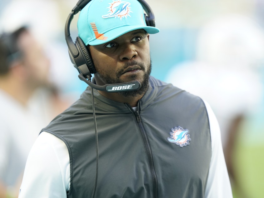 caption: Miami Dolphins head coach Brian Flores watches a play during the first half of an NFL football game against the Carolina Panthers, Sunday, Nov. 28, 2021, in Miami Gardens, Fla.