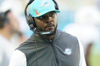 caption: Miami Dolphins head coach Brian Flores watches a play during the first half of an NFL football game against the Carolina Panthers, Sunday, Nov. 28, 2021, in Miami Gardens, Fla.