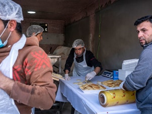 caption: A pop-up bakery in the town of Shoubak, Jordan, offers traditional Ramadan dessert known as <em>qatayef</em> a day before the start of the holy month.