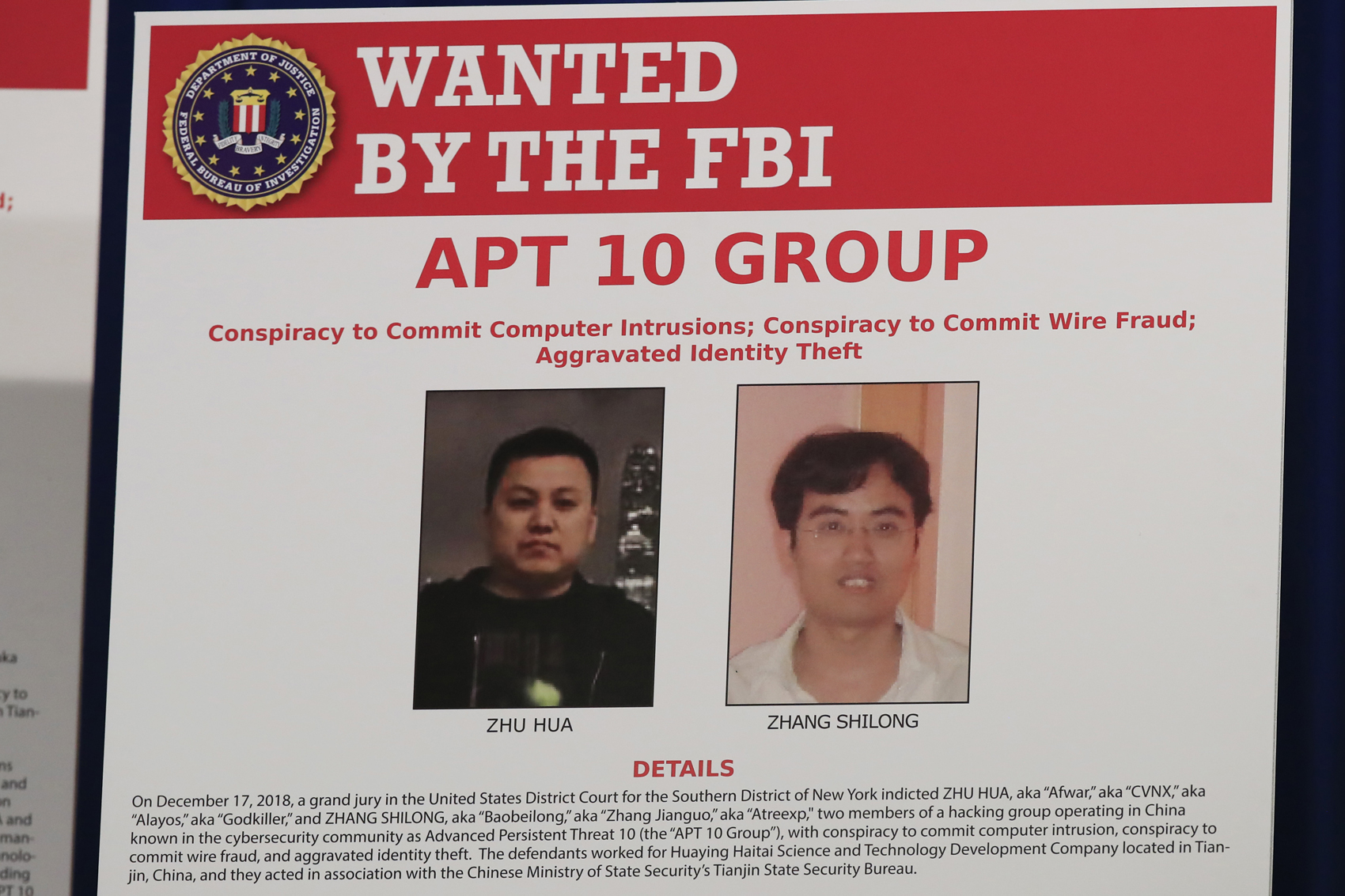 caption: A poster displayed during a news conference at the Department of Justice in Washington, Thursday, Dec. 20, 2018, shows two Chinese citizens suspected to be with the group APT 10 carrying out an extensive hacking campaign to steal data from U.S. companies. (Manuel Balce Ceneta/AP)