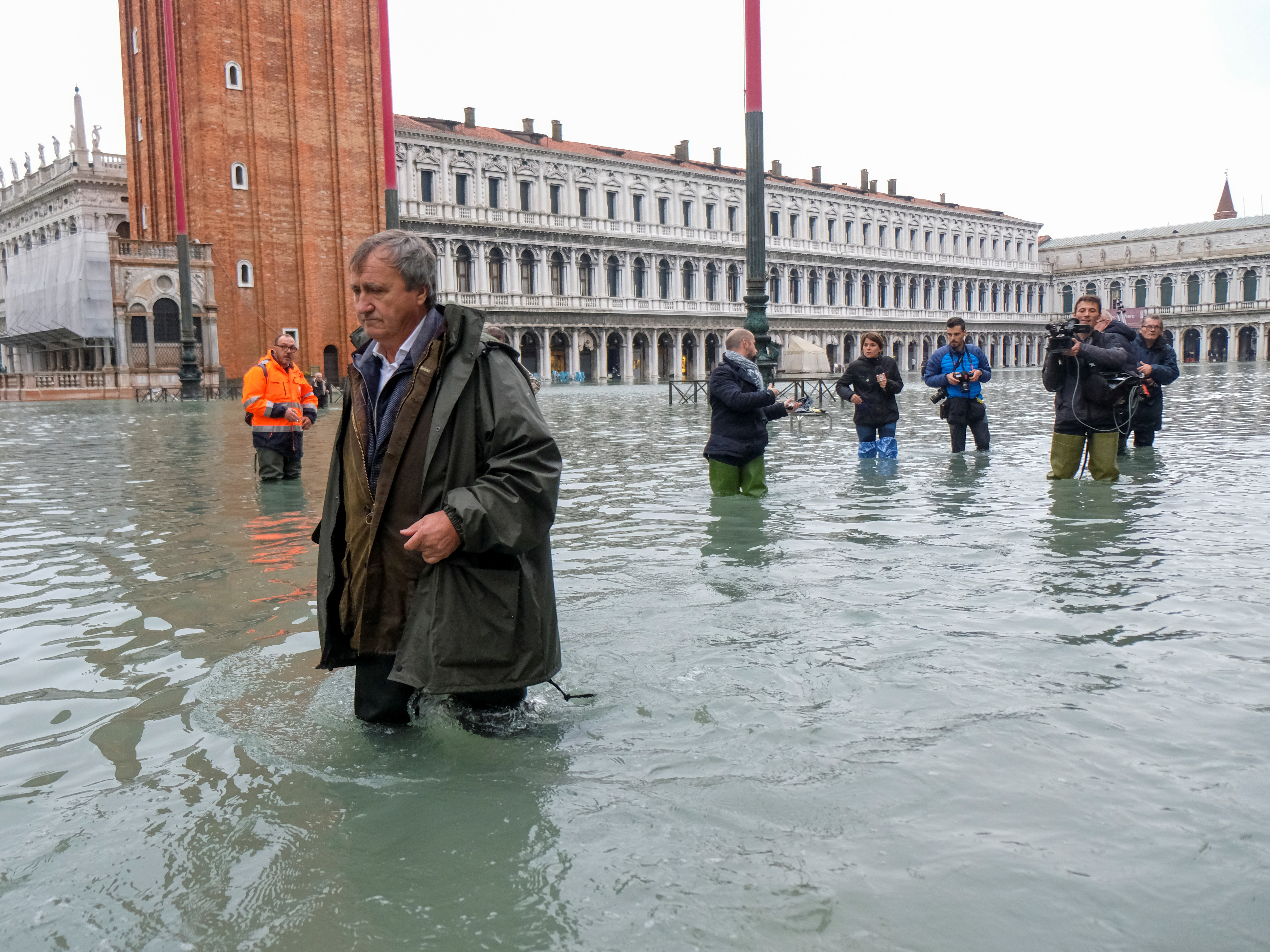 caption: Venice Mayor Luigi Brugnaro trudges through high water in St. Mark's Square on Wednesday, the result of an exceptionally high tide in the scenic Italian city.