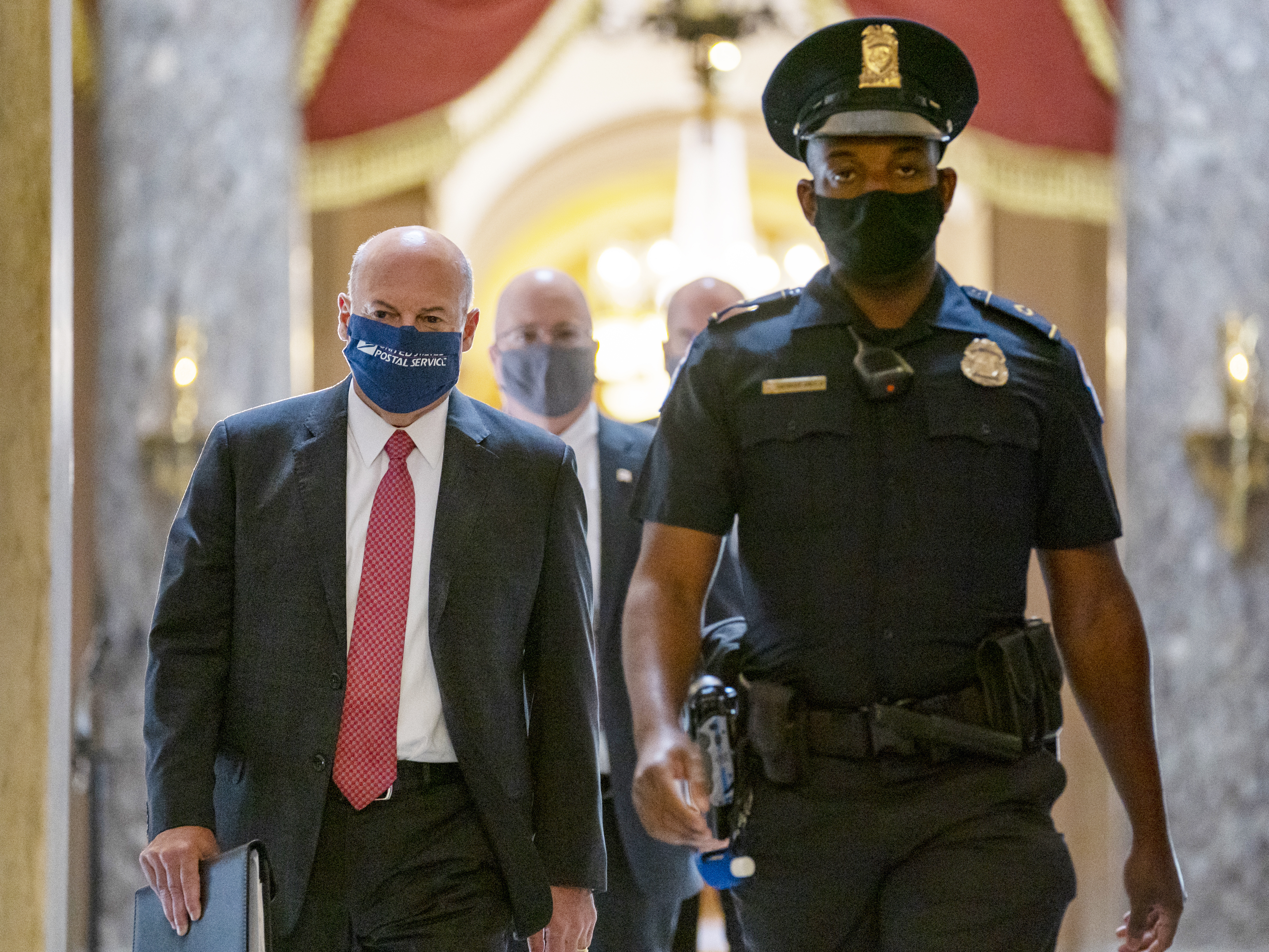 caption: Postmaster General Louis DeJoy, left, while visiting Capitol Hill earlier this month. DeJoy is set to testify before Senate and House panels in the coming days over his controversial plans to cut costs at the sprawling postal service, which many Democrats fear could slow the delivery of mail ballots this fall.