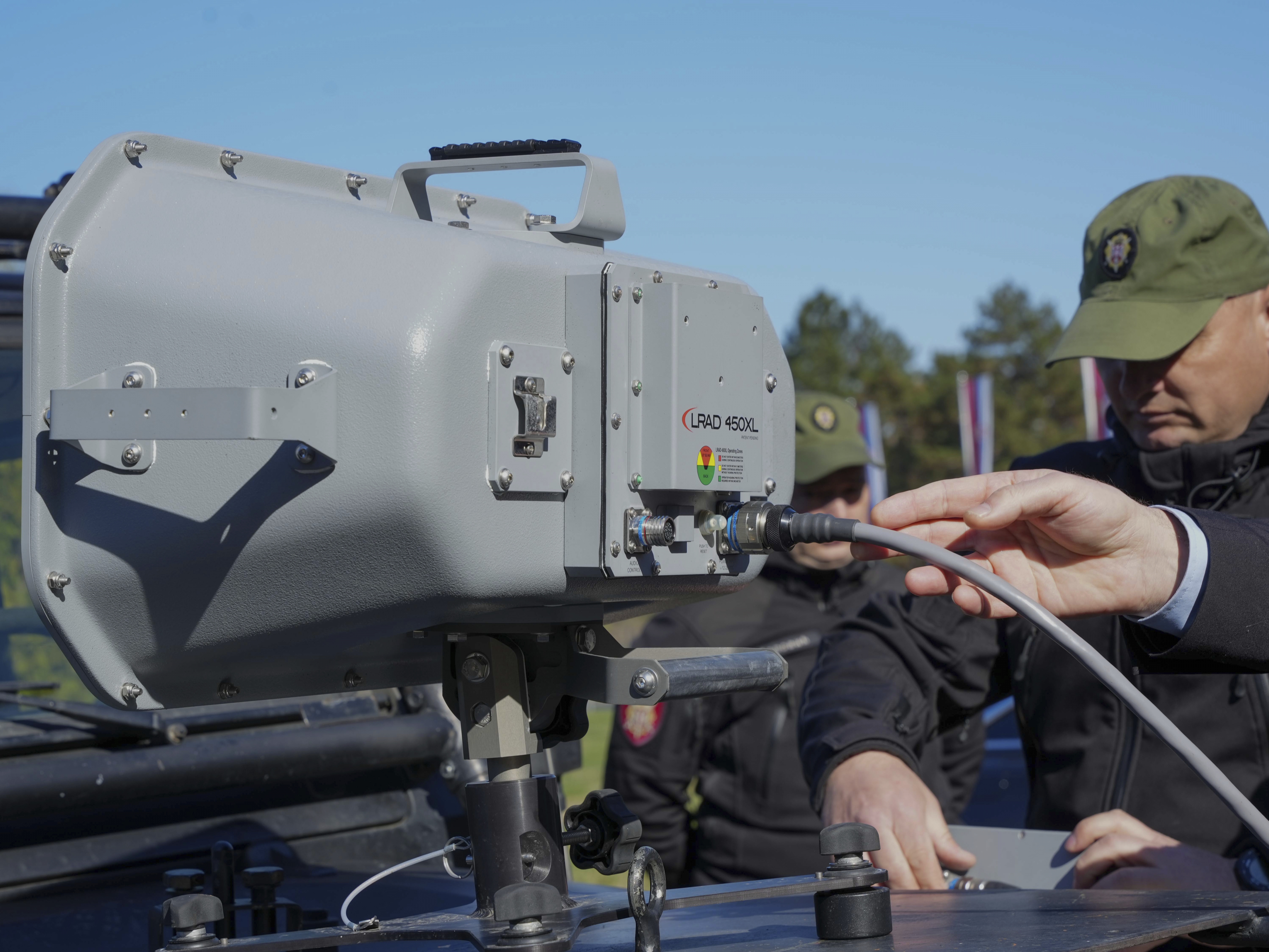 caption: In this photo provided by the Serbian Interior Ministry, Serbian Gendarmerie officers show the U.S.-made Long Range Acoustic Device (LRAD), which is illegal in Serbia and many other countries, in Belgrade, Serbia, on March 19.