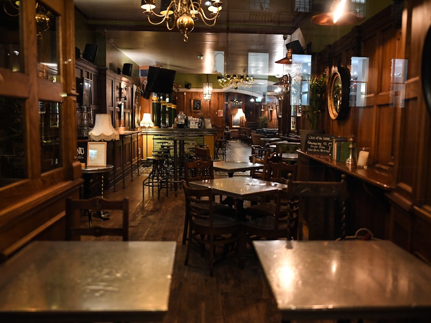 caption: An empty pub in London. On Friday, British Prime Minister Boris Johnson announced that the country's bars, pubs, restaurants and cafes must close  to curb the spread of COVID-19, which has killed more than 100 people in the U.K.