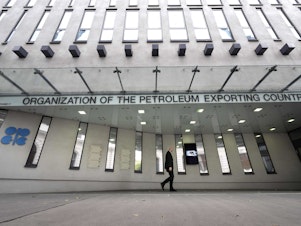 caption: A man walks past OPEC headquarters in Vienna on Tuesday on the eve of the 45th meeting of the Joint Ministerial Monitoring Committee and the 33rd OPEC and non-OPEC Ministerial Meeting. The in-person meeting of OPEC members led by Saudi Arabia and allied members headed by Russia will be the first in the Austrian capital since the spring of 2020.