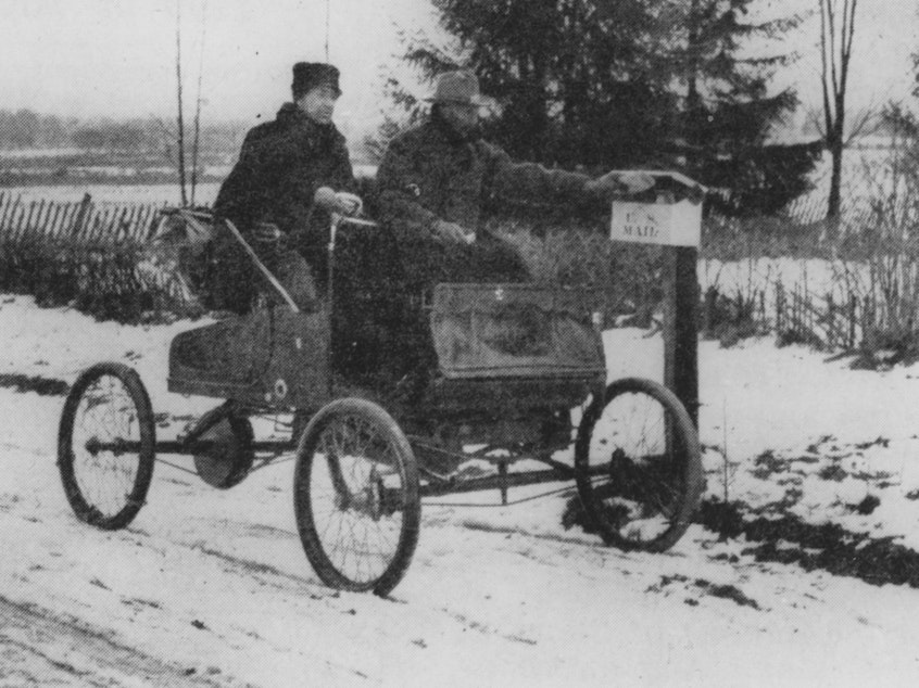 caption: A rural mail carrier in 1905 trying out new transportation technology.