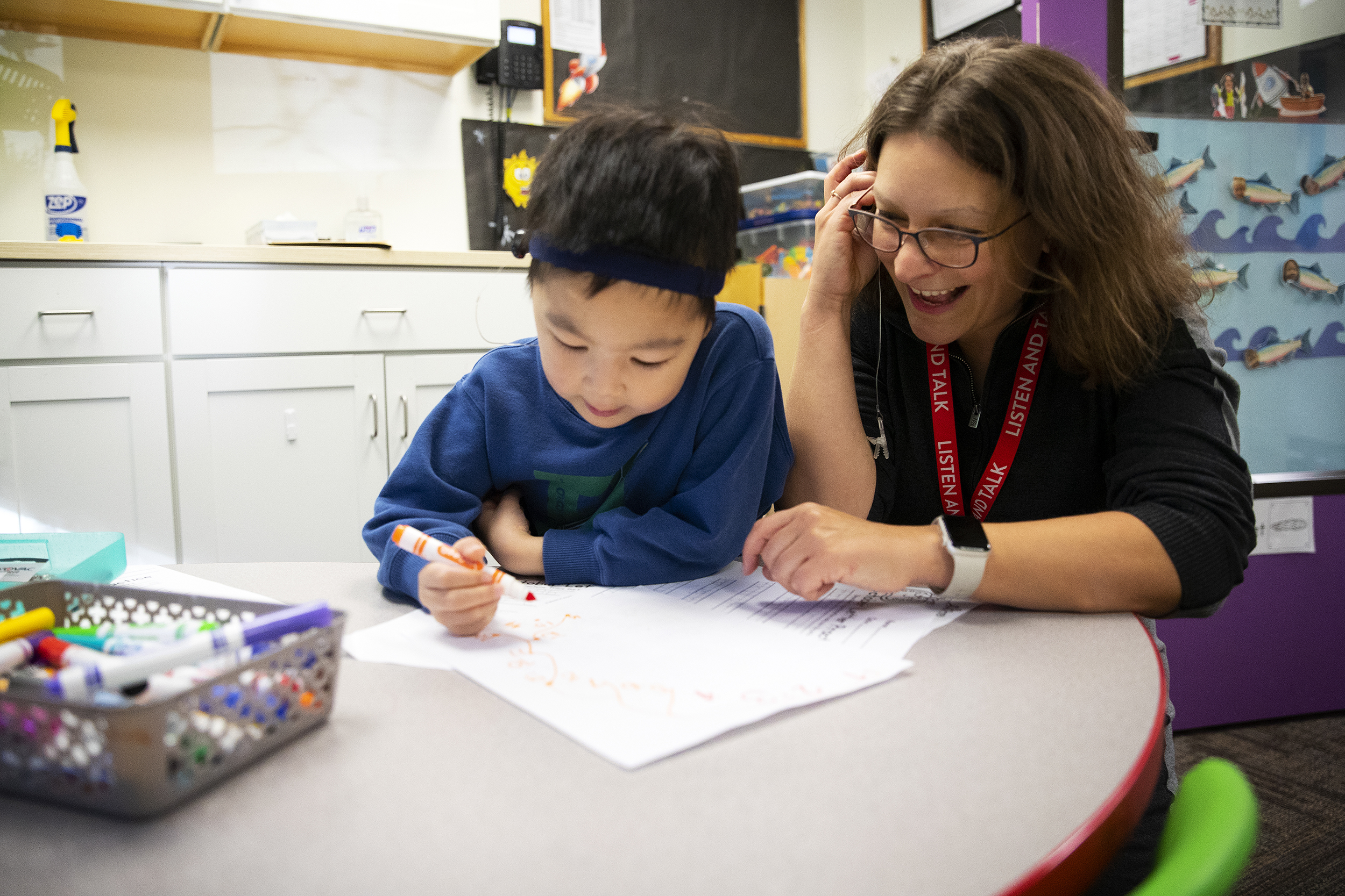 caption: Mona Oster, education and research director at Listen and Talk, checks the function of 5-year-old Bowen Gong’s bone oscillating processor hearing aid, on Tuesday, October 14, 2025, in Kirkland. 