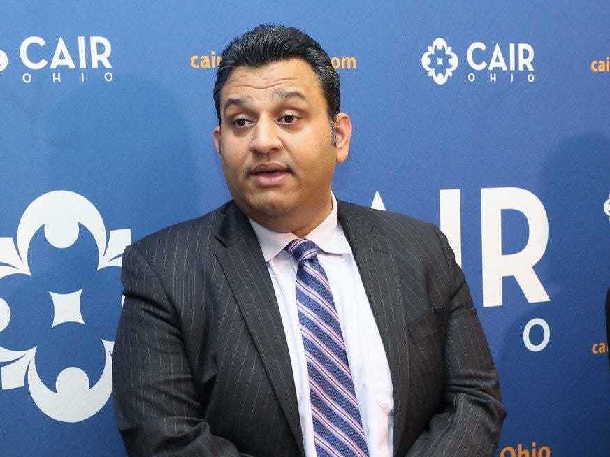 caption: Romin Iqbal (center) of the Council on American-Islamic Relations (CAIR) attends a press conference at CAIR-Columbus headquarters in Columbus, Ohio, in 2018. Iqbal was terminated for sharing information about the organization to "a known anti-Muslim hate group."