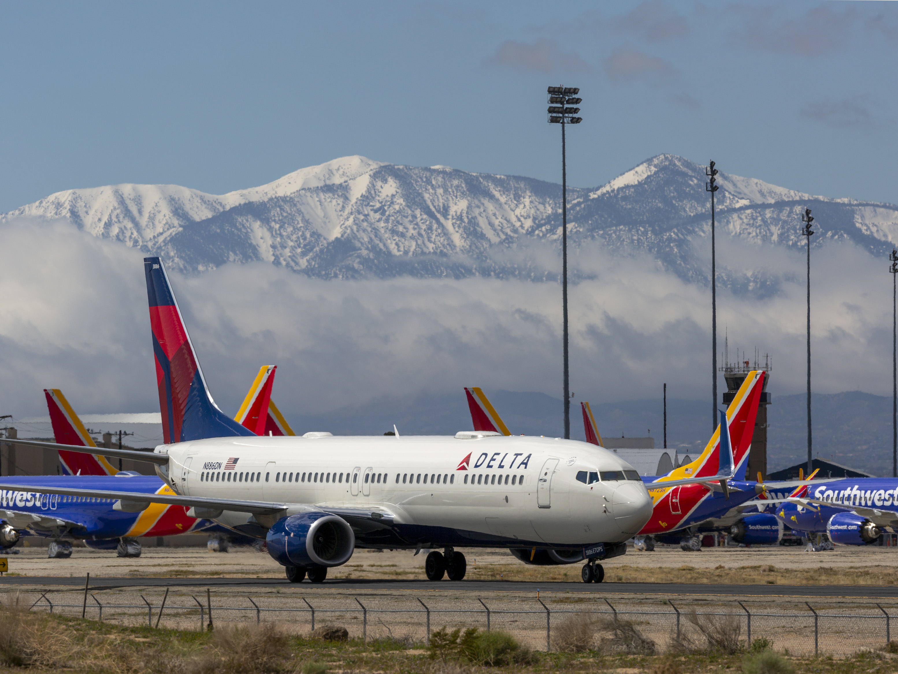 caption: A Delta Air Lines jet seen parking at Southern California Logistics Airport (SCLA) in March 2020, in Victorville, Calif.
